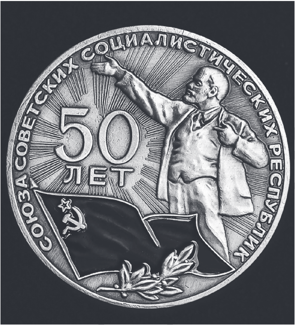 Памятная медаль: надпись по кругу «Союза Советских Социалистических Республик», крупно «50 лет», фигура В.И. Ленина с вытянутой рукой на фоне лучей, внизу развёрнутое знамя с серпом, молотом и звездой и лавровая ветвь